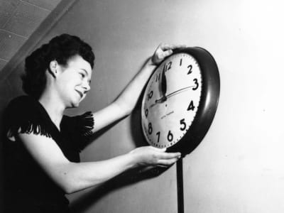 Vera Croucher adjusting a clock for daylight savings time promotion, captured by the City of Edmonton Archives.